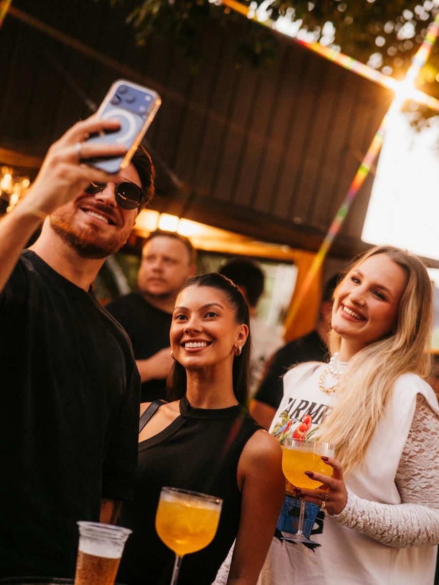 Amigos fazendo selfie com drinks
